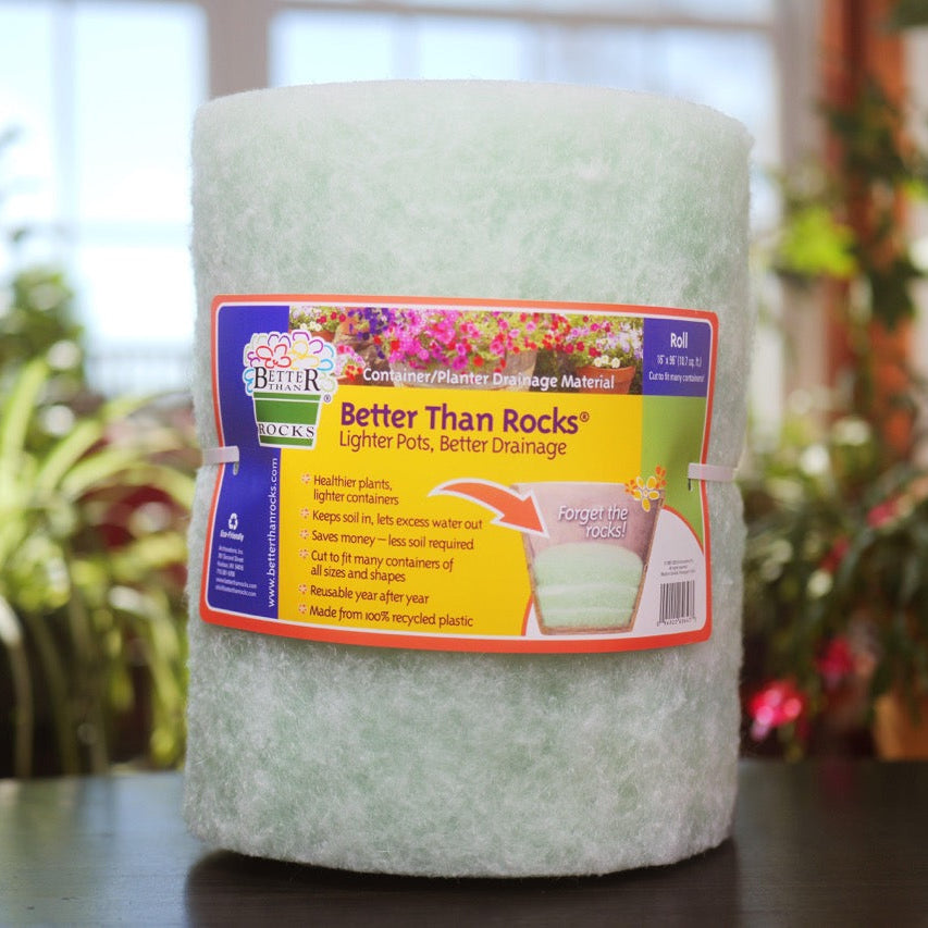 Better Than Rocks 16" × 96" Jumbo Roll drainage insert displayed on a table with indoor plants in the background, ideal for extra-large planters and large containers.