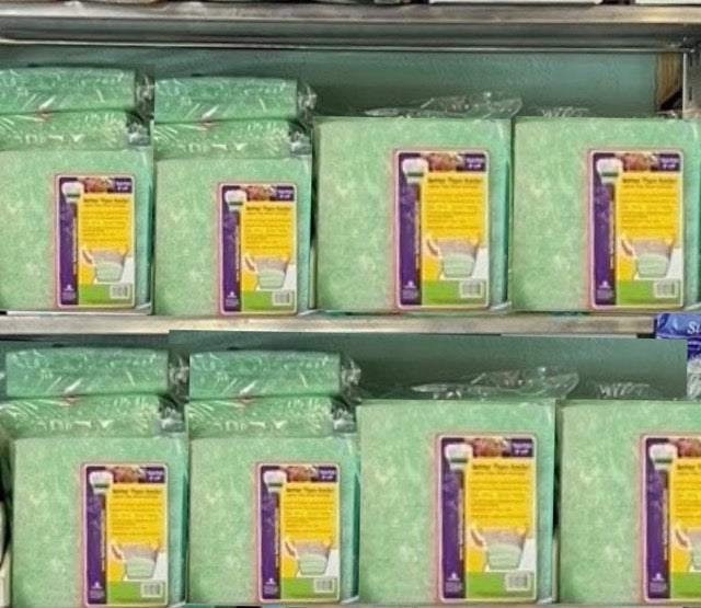 Multiple Better Than Rocks retail packs arranged on a shelf display in a garden center, showing the product's compact packaging and suitability for positioning near planters or potting soil.